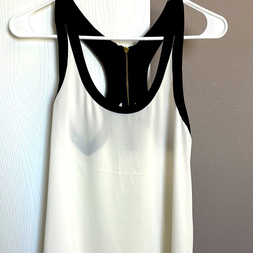 Express tank top in an off white with black straps and gold zipper detail.